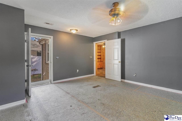 unfurnished bedroom with ceiling fan and a textured ceiling