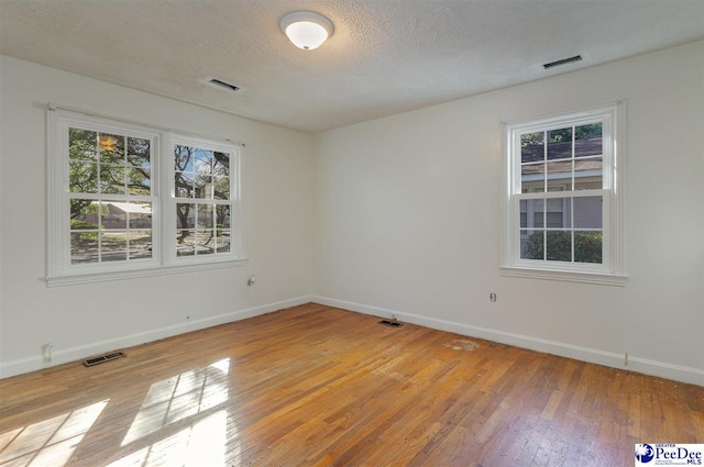 empty room featuring light hardwood / wood-style floors and a textured ceiling