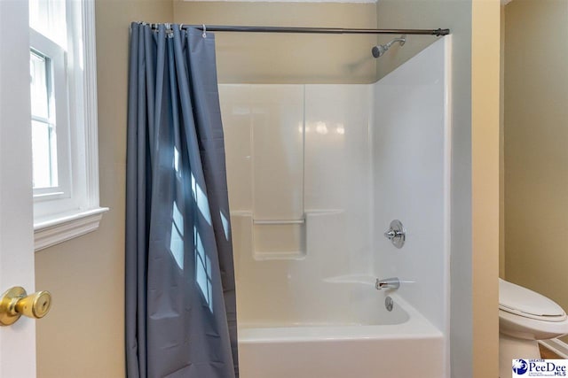 bathroom featuring shower / tub combo with curtain and toilet