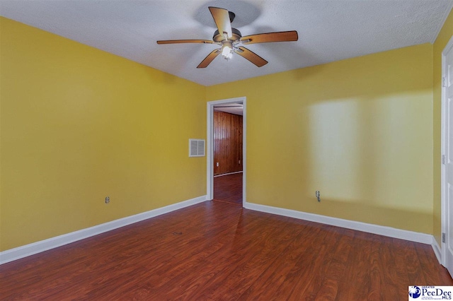 unfurnished room featuring ceiling fan, dark hardwood / wood-style floors, and a textured ceiling