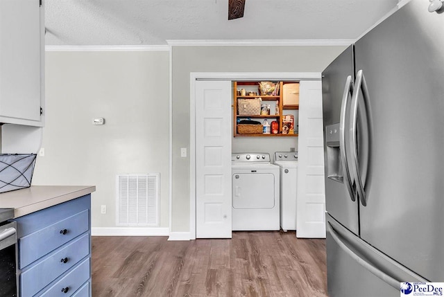 108 Wyandot St, Darlington, SC 29532 - kitchen with stainless steel fridge, washing machine and dryer, wood finished floors, ornamental molding, and light countertops