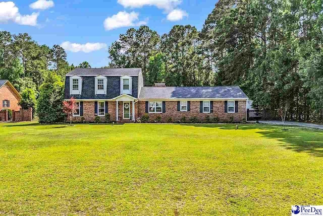 108 Wyandot St, Darlington, SC 29532 - dutch colonial featuring a front yard, brick siding, and view of scattered trees