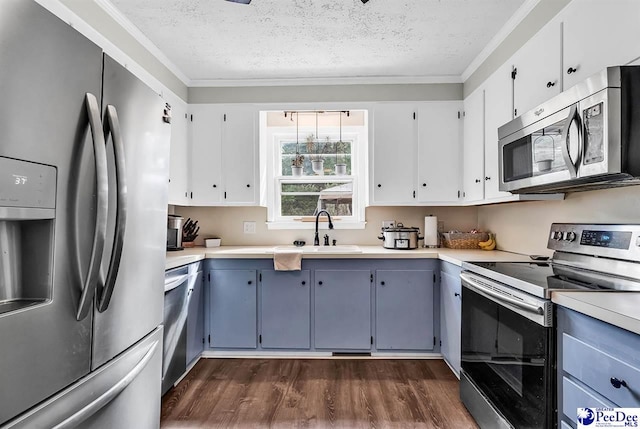 108 Wyandot St, Darlington, SC 29532 - kitchen featuring stainless steel appliances, a textured ceiling, dark wood-type flooring, ornamental molding, and light countertops