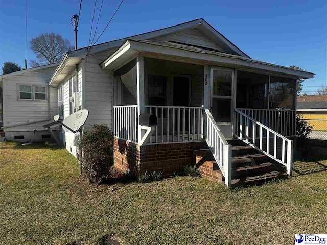 view of front of property featuring a sunroom, a front yard, and crawl space