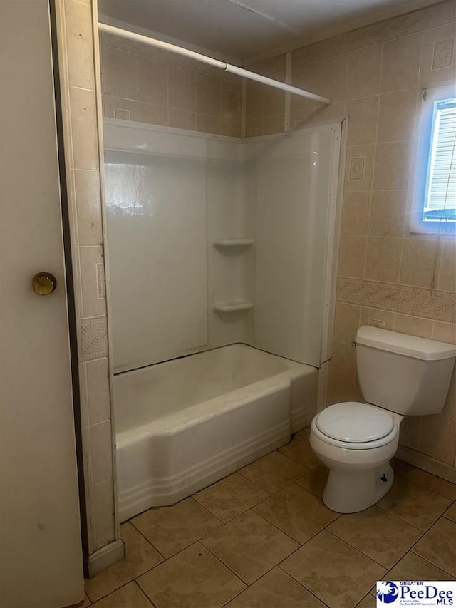 full bathroom with washtub / shower combination, tile walls, toilet, and tile patterned floors