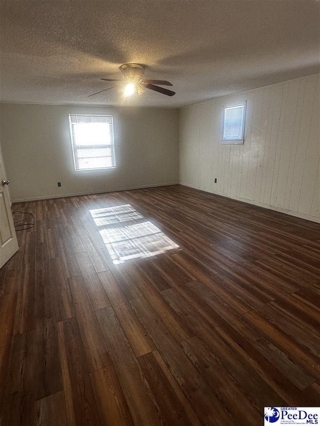 spare room with ceiling fan, dark wood-style flooring, and a textured ceiling