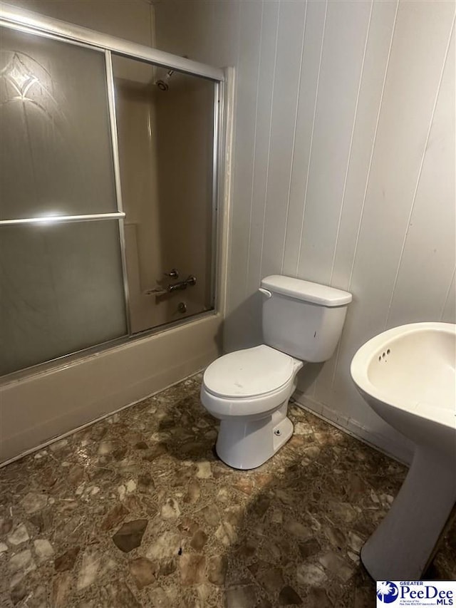 full bath with toilet and bath / shower combo with glass door