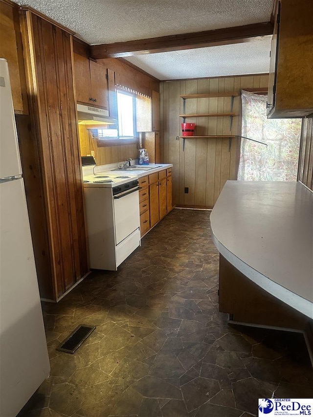 kitchen featuring brown cabinets, light countertops, visible vents, white appliances, and under cabinet range hood