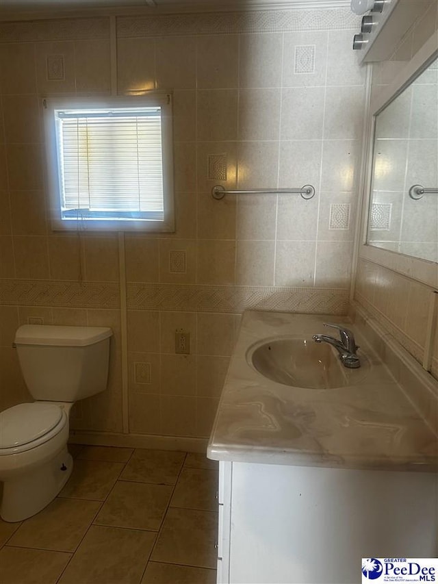 bathroom featuring toilet, tile patterned flooring, tile walls, and vanity