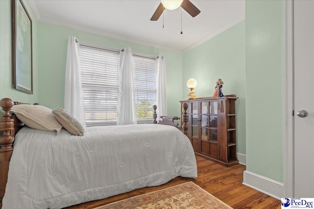 bedroom featuring hardwood / wood-style flooring, ornamental molding, and ceiling fan