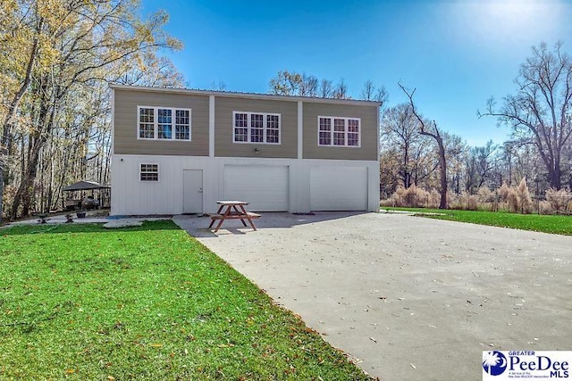 rear view of property with a yard and a garage