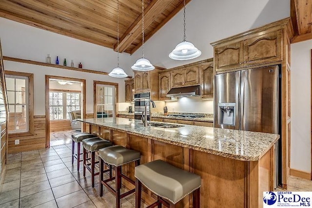 kitchen featuring sink, vaulted ceiling with beams, wood ceiling, hanging light fixtures, and an island with sink