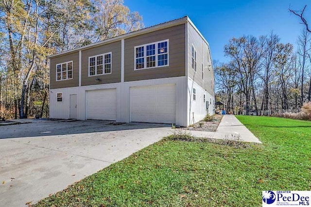 exterior space featuring a garage and a lawn