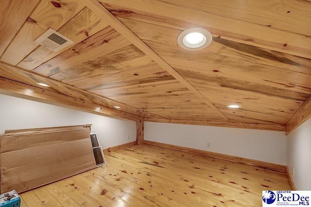 additional living space with lofted ceiling and hardwood / wood-style flooring