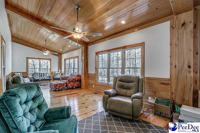 living room featuring lofted ceiling, wood walls, wood-type flooring, wooden ceiling, and ceiling fan