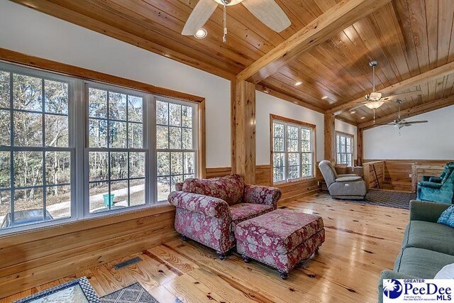 living room featuring hardwood / wood-style flooring, ceiling fan, vaulted ceiling with beams, and wood ceiling