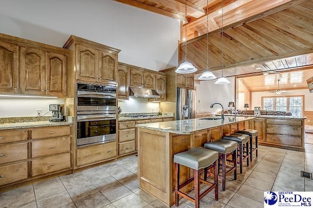 kitchen with wood ceiling, stainless steel appliances, a center island with sink, decorative light fixtures, and beamed ceiling