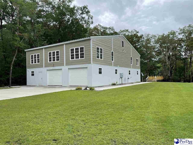 view of side of home featuring a garage and a yard