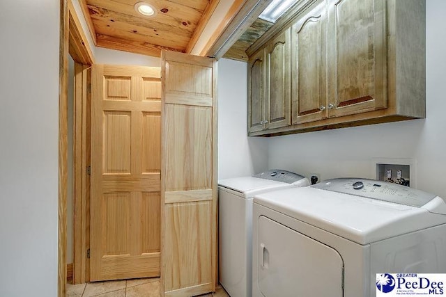 clothes washing area featuring cabinets, light tile patterned flooring, separate washer and dryer, and wood ceiling