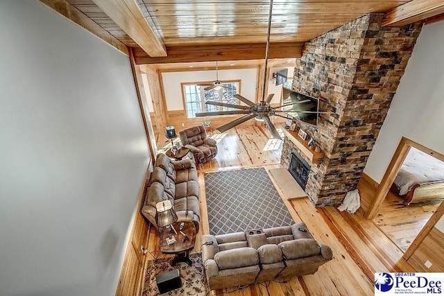 living room with hardwood / wood-style flooring, wood ceiling, a fireplace, and beamed ceiling