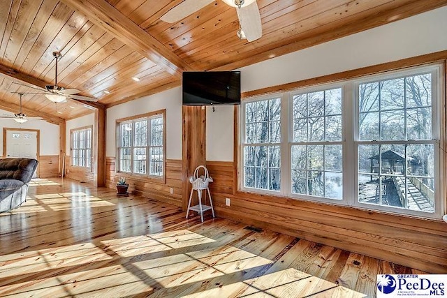 unfurnished sunroom featuring wood ceiling, lofted ceiling with beams, and ceiling fan