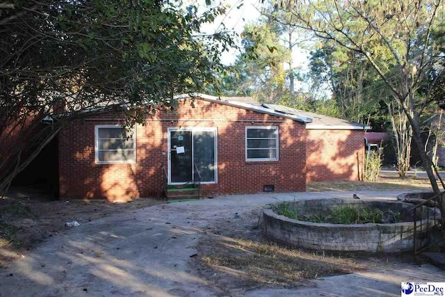 view of front of house featuring crawl space and brick siding