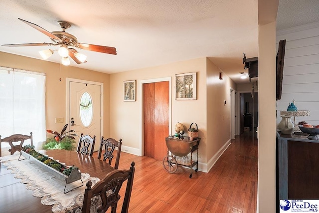 dining room featuring a ceiling fan, baseboards, and light wood finished floors