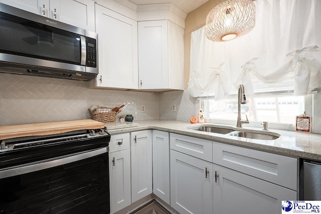 kitchen with black electric range, white cabinetry, stainless steel microwave, and a sink