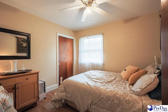 bedroom with ceiling fan, a closet, baseboards, and wood finished floors