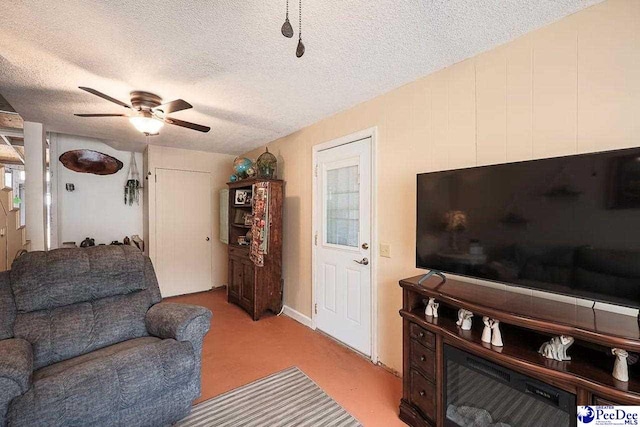 living area featuring a textured ceiling, ceiling fan, and carpet flooring