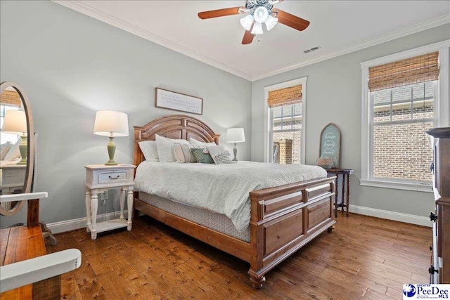 bedroom with baseboards, visible vents, dark wood-style flooring, ceiling fan, and crown molding