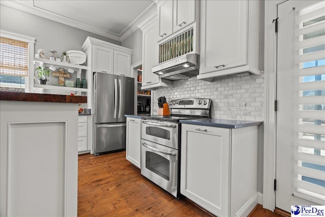 kitchen featuring ornamental molding, under cabinet range hood, dark countertops, white cabinetry, and stainless steel appliances