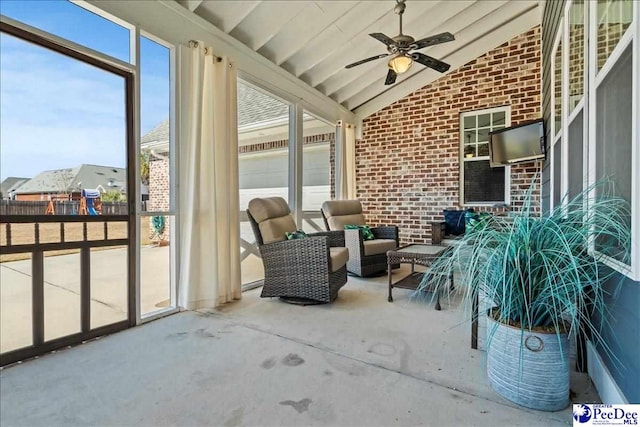 sunroom with lofted ceiling and a ceiling fan