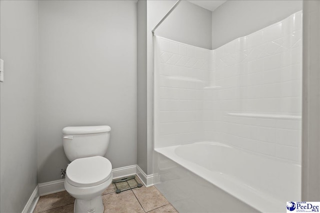 bathroom featuring tile patterned flooring, toilet, shower / bathing tub combination, and baseboards