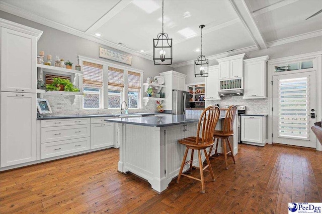 kitchen featuring open shelves, a kitchen island, hardwood / wood-style floors, appliances with stainless steel finishes, and white cabinets