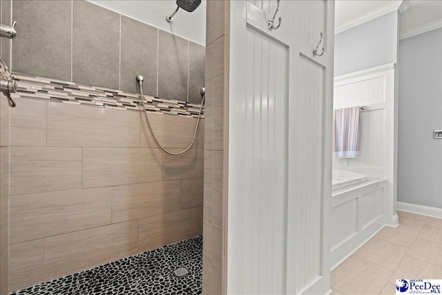 bathroom with a tile shower, a garden tub, crown molding, and baseboards