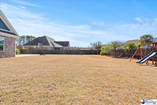 view of yard with a playground and a fenced backyard