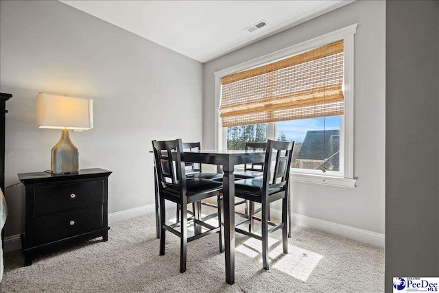 dining space featuring visible vents, baseboards, carpet flooring, and vaulted ceiling