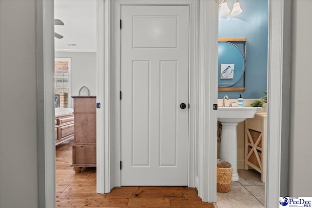 hallway featuring hardwood / wood-style floors and ornamental molding