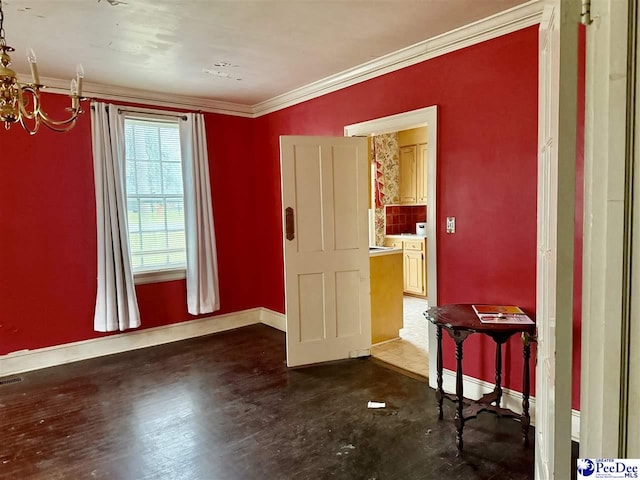 empty room featuring ornamental molding, visible vents, baseboards, and a chandelier