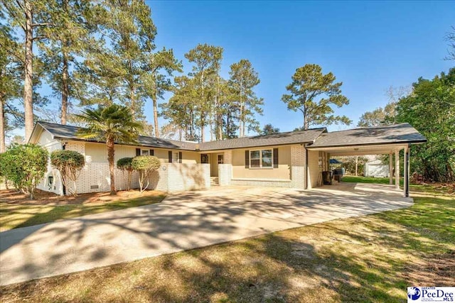 ranch-style house with concrete driveway, a carport, crawl space, and brick siding