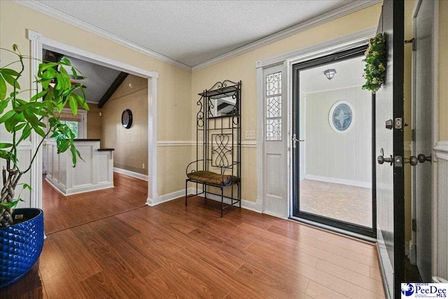 entryway featuring a textured ceiling, wood finished floors, and crown molding