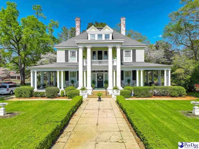 601 E Main St, Dillon, SC 29536 - greek revival house featuring a porch, a chimney, and a front yard