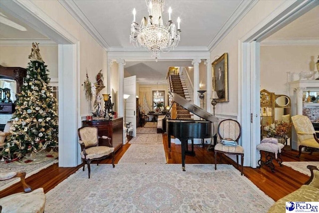 corridor featuring crown molding, a chandelier, and wood finished floors