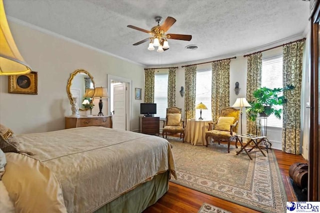 bedroom with ornamental molding, wood finished floors, and multiple windows