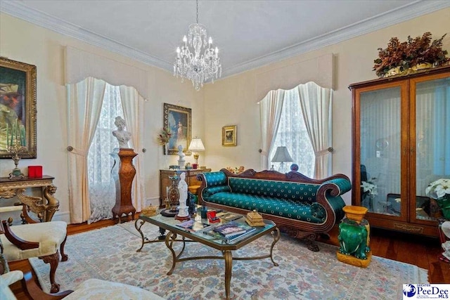 living area with crown molding, a notable chandelier, and wood finished floors