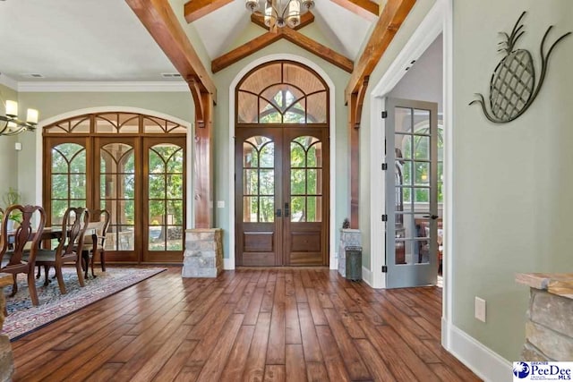 entrance foyer with a notable chandelier, lofted ceiling with beams, hardwood / wood-style floors, and french doors