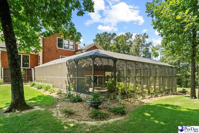 exterior space featuring glass enclosure and a lawn