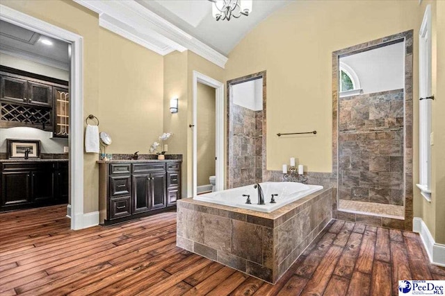 full bathroom featuring hardwood / wood-style flooring, crown molding, vanity, and toilet