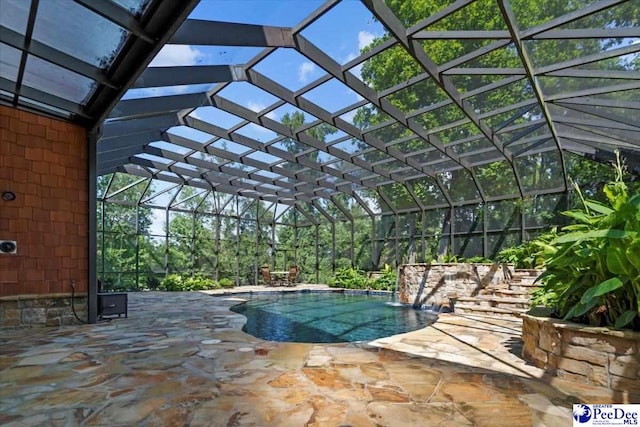 view of pool with pool water feature, glass enclosure, and a patio area